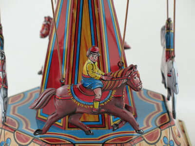 Blech Pferdekarussell mit detailiertem Reiter auf einem Pferd und farbenfrohem Design.