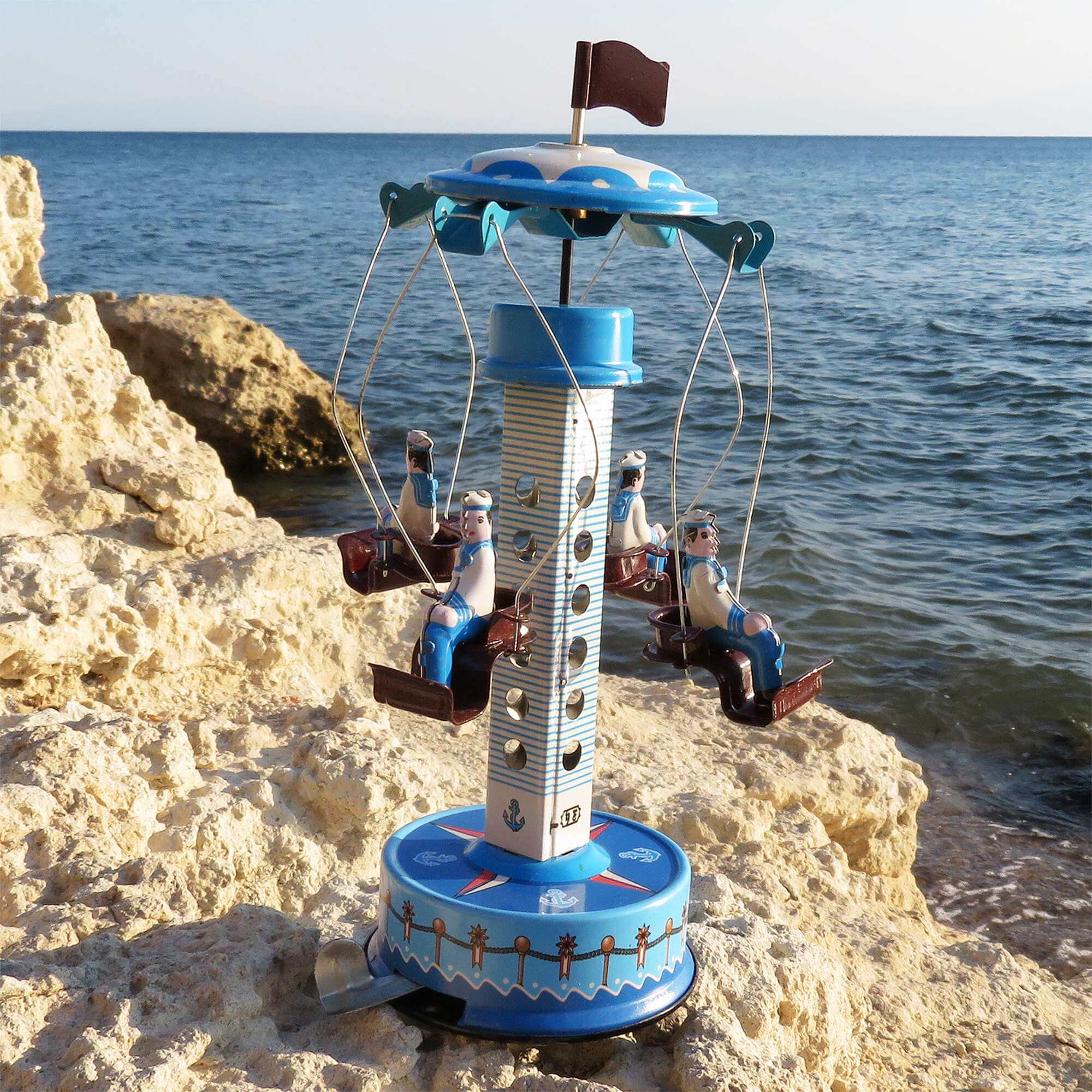 Handaufgezogenes Blechkarussell Matrosen – Nostalgisches Vintage Spielzeug am Ufer, mit Matrosen Figuren und maritimen Design.